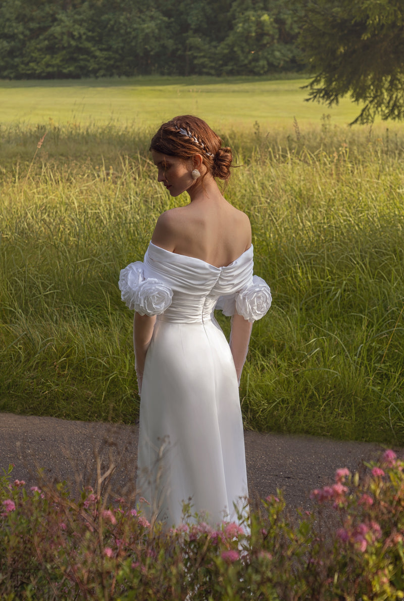 Vestido de novia minimalista de seda con hombros descubiertos y guantes de rosas en 3D