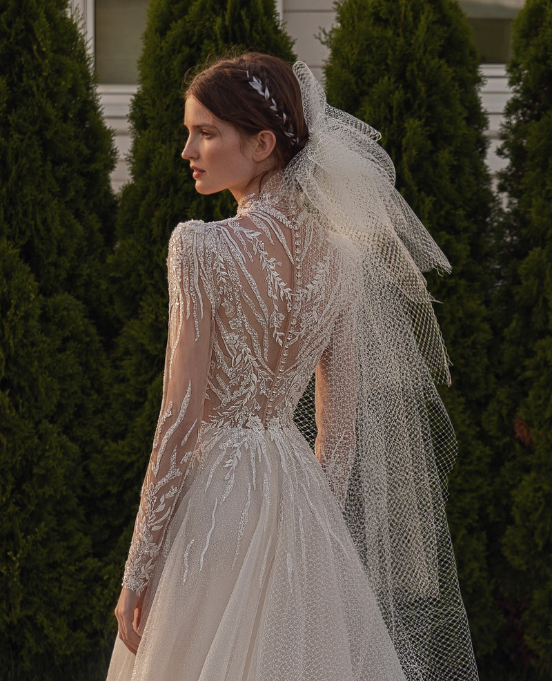 Vestido de novia con purpurina y cuello alto de manga larga