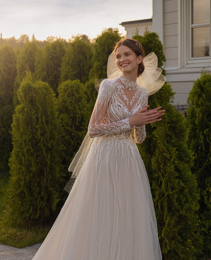 Vestido de novia con purpurina y cuello alto de manga larga